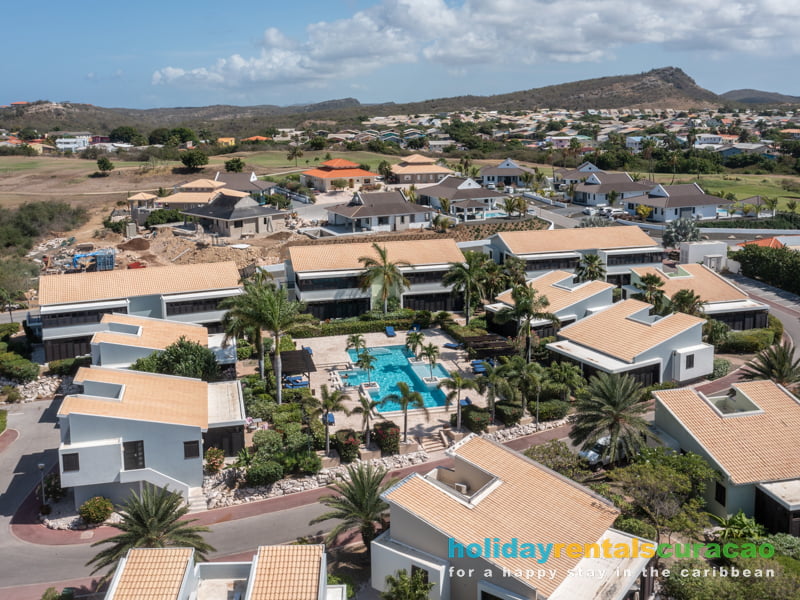 Luftaufnahme des Swimmingpools und der Ferienhäuser im Blue Bay Resort Curacao