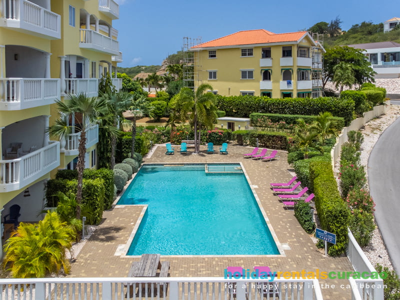Schwimmbad umgeben von viel Grün und Palmen Blue Bay Resort Curacao